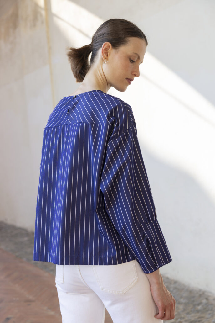 Maritim: Die Cropped Bluse „Mia“ besticht mit diagonal gelegter Schulterpartie, 7/8-Ärmeln mit Schlitz und Kräuselung sowie TwoPly-Streifen aus dem Hause Thomas Mason.